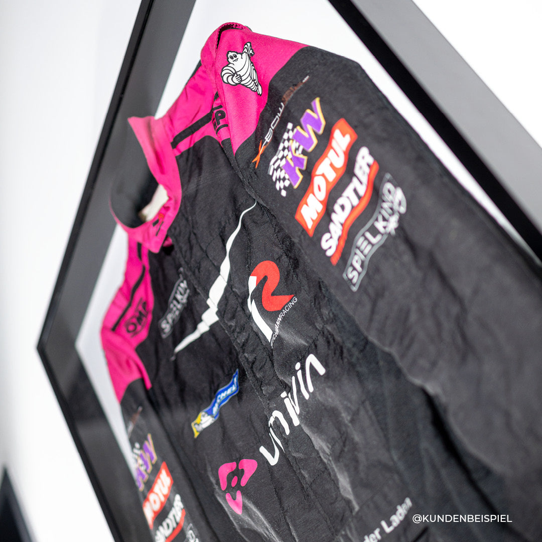Rennanzug im Living.Steel Rahmen – hochwertig gerahmte Motorsport-Erinnerung mit Acrylglasfront und maßgefertigtem schwarzen Rahmen. Kundenbeispiel.