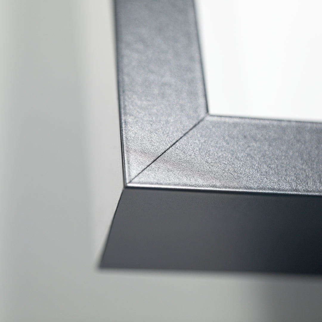 Nahaufnahme der präzisen Rahmenecke eines Living.Steel Trikotrahmens – hochwertige Verarbeitung in Schwarz mit feiner Gehrung und klarer Linienführung.
