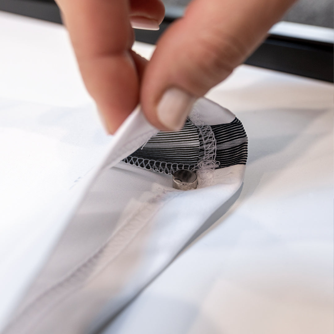 Magnetische Rückwand des Living.Steel Trikotrahmens in Aktion – einfache, rahmenschonende Platzierung des Trikots dank cleverem Magnetsystem.